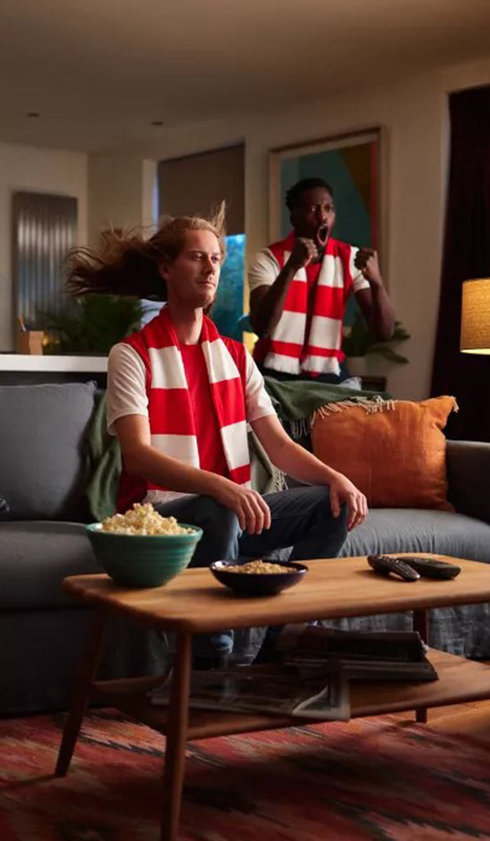 Bild zeigt ein Mann sitzend auf einer Couch 